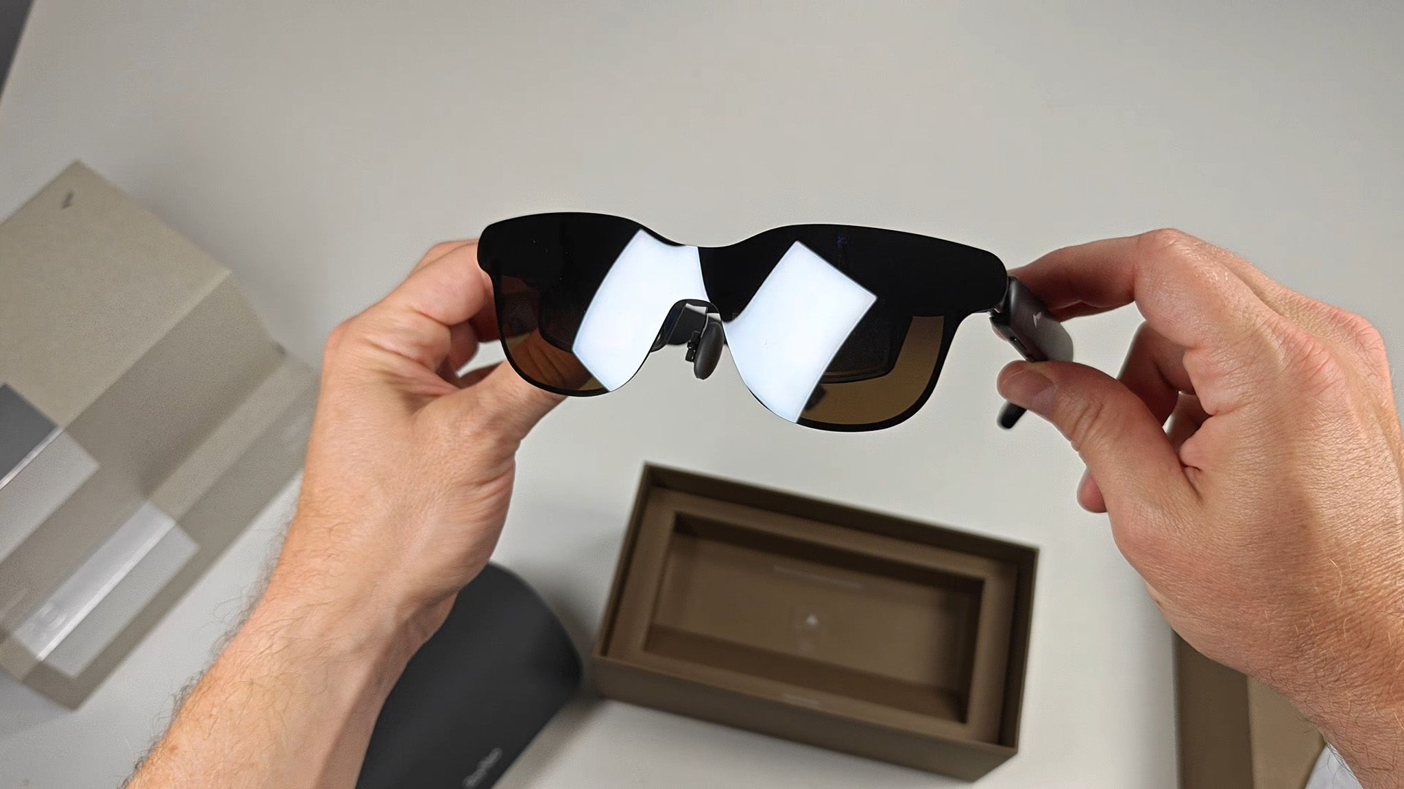 A sleek, modern pair of RayNeo smart glasses with subtle tech features visible on the frame.