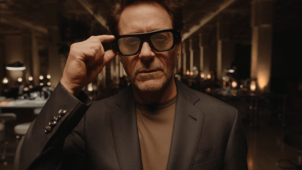 Robert Downey Jr. wearing Snap Specs AR glasses, looking forward with a slight smile.